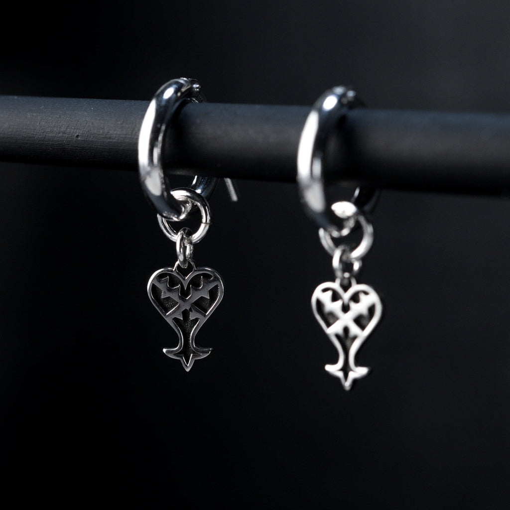 Detail of Kage hoop earrings showing inverted heart charm in sterling silver