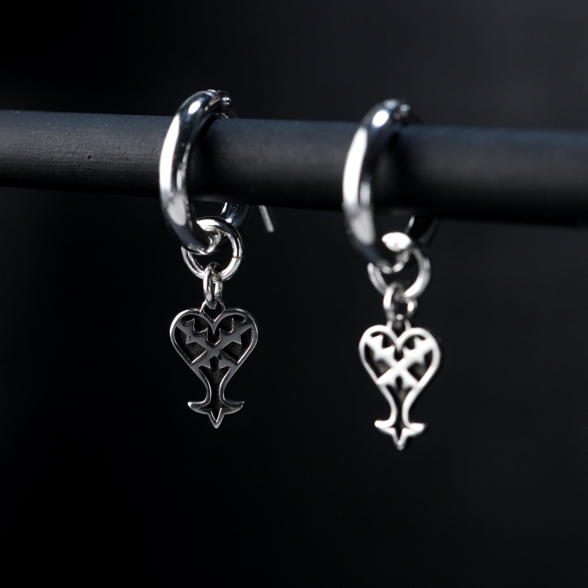 Detail of Kage hoop earrings showing inverted heart charm in sterling silver