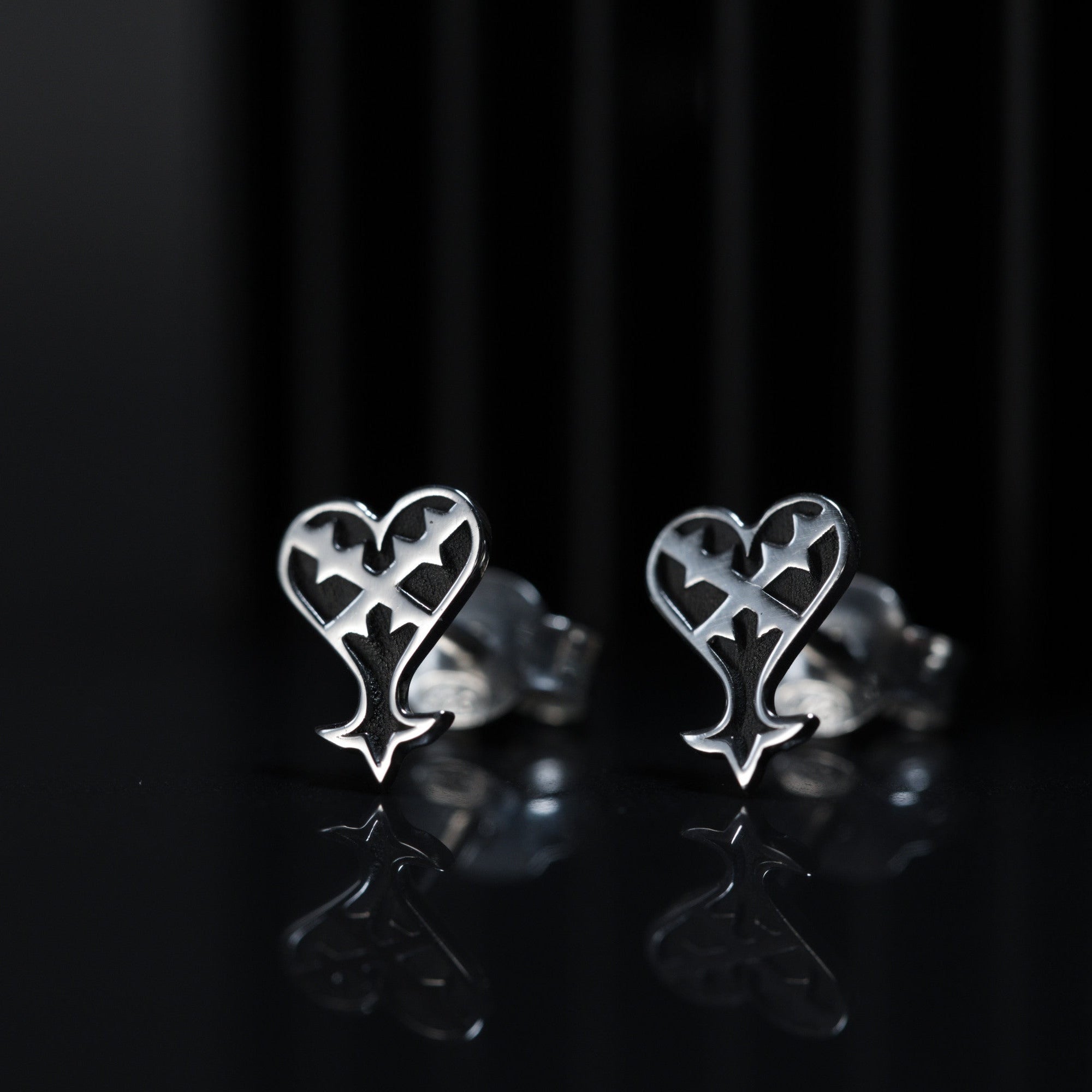 Detail of Kage stud earrings showing inverted heart design in sterling silver