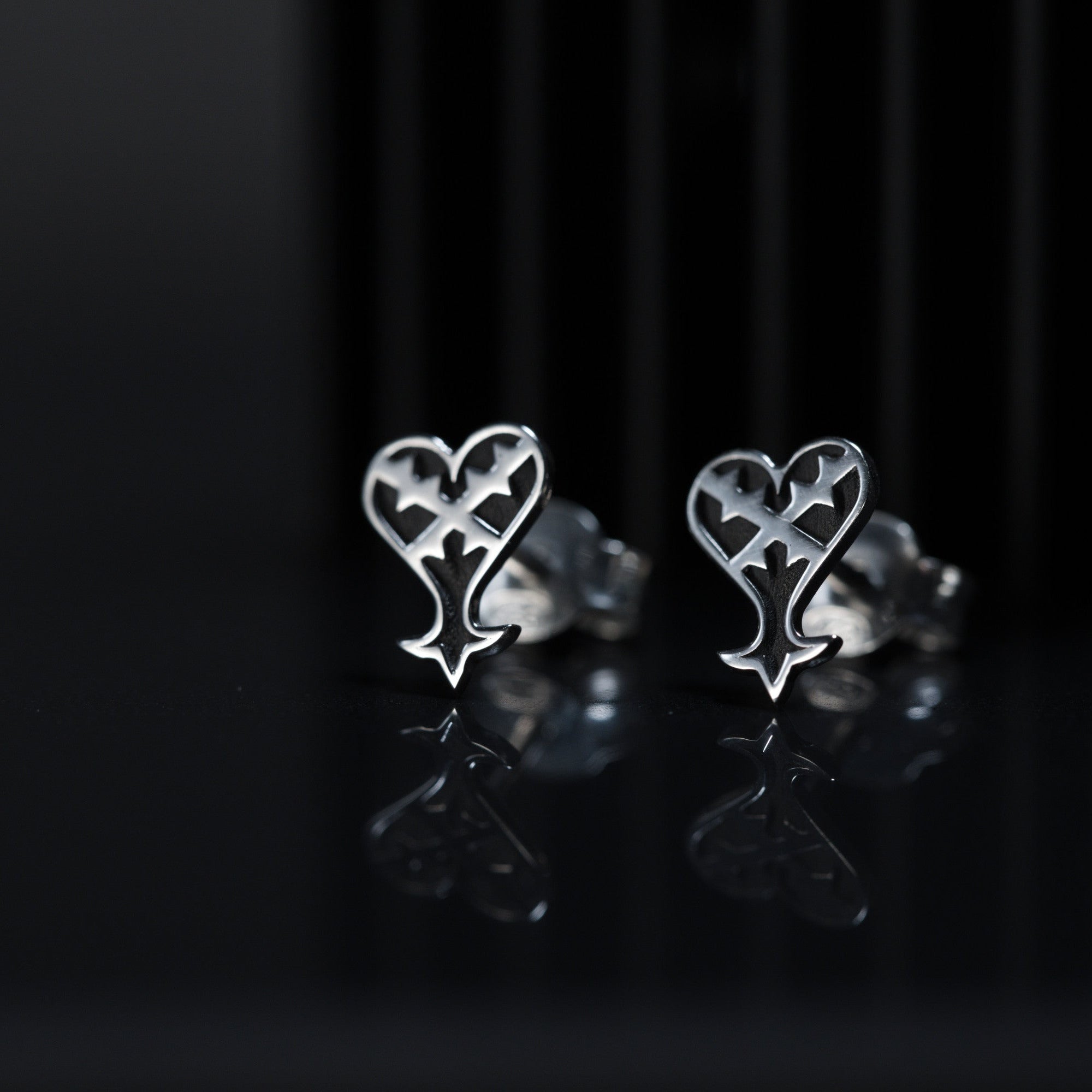 Kage stud earrings in sterling silver with inverted heart symbol representing darkness