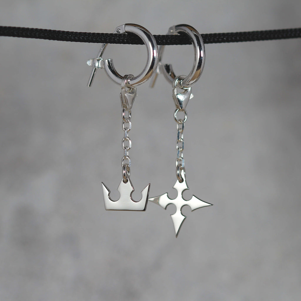 Full view of Korona chain earrings in sterling silver with crown and cross symbols and chain detail