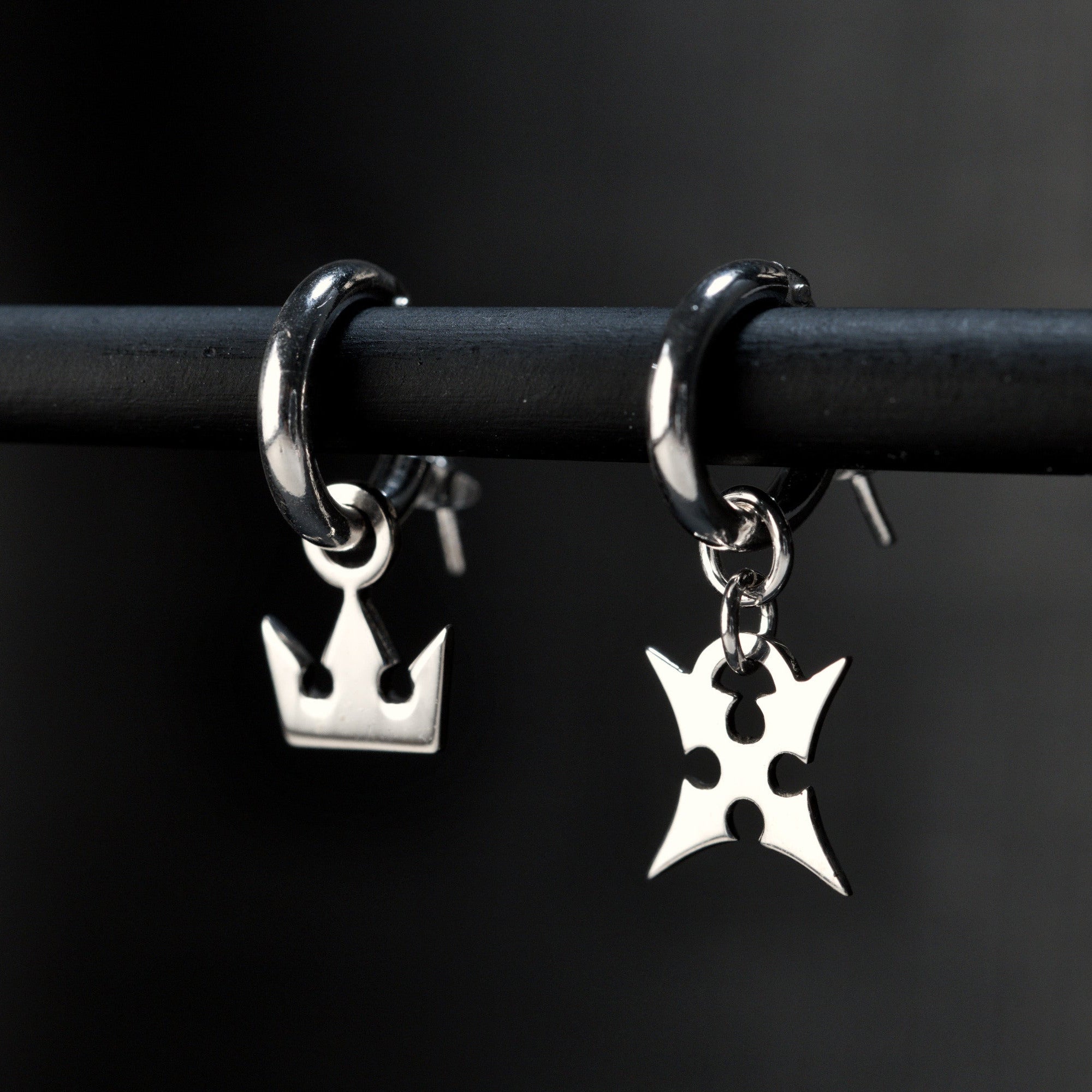 Korona hoop earrings in sterling silver with crown and cross symbols representing light and darkness