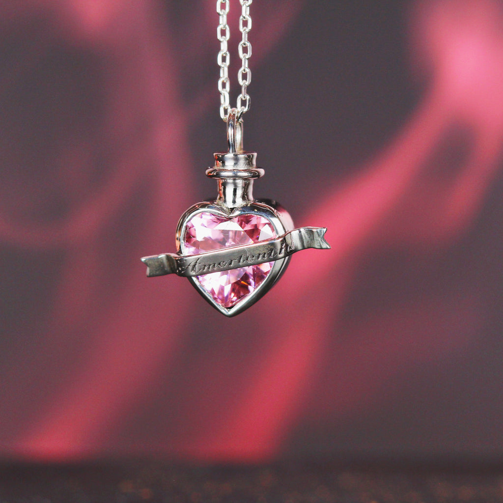 Close-up of love elixir pendant with pink heart stone