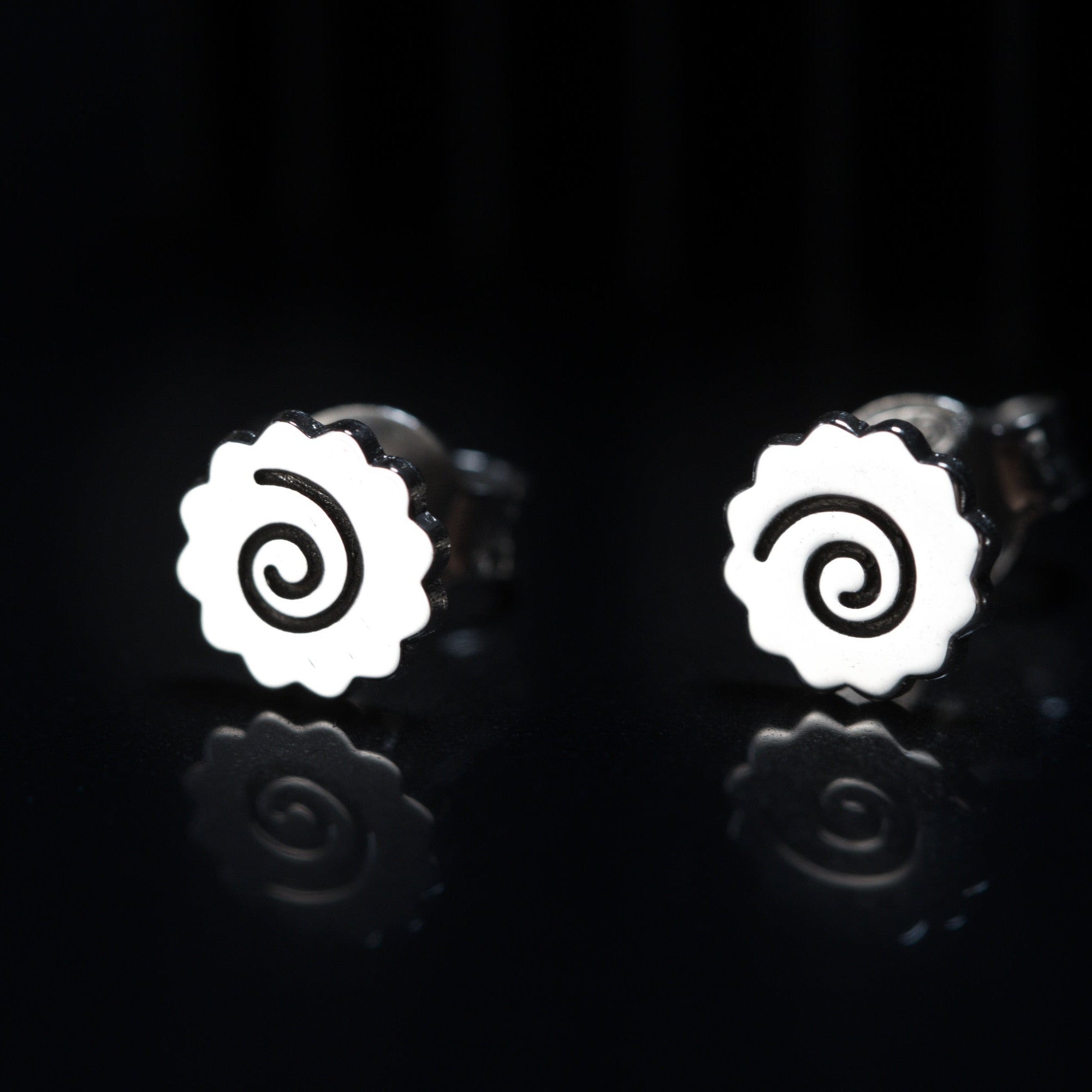 Detail of ramen earrings showing spiral narutomaki shape in sterling silver