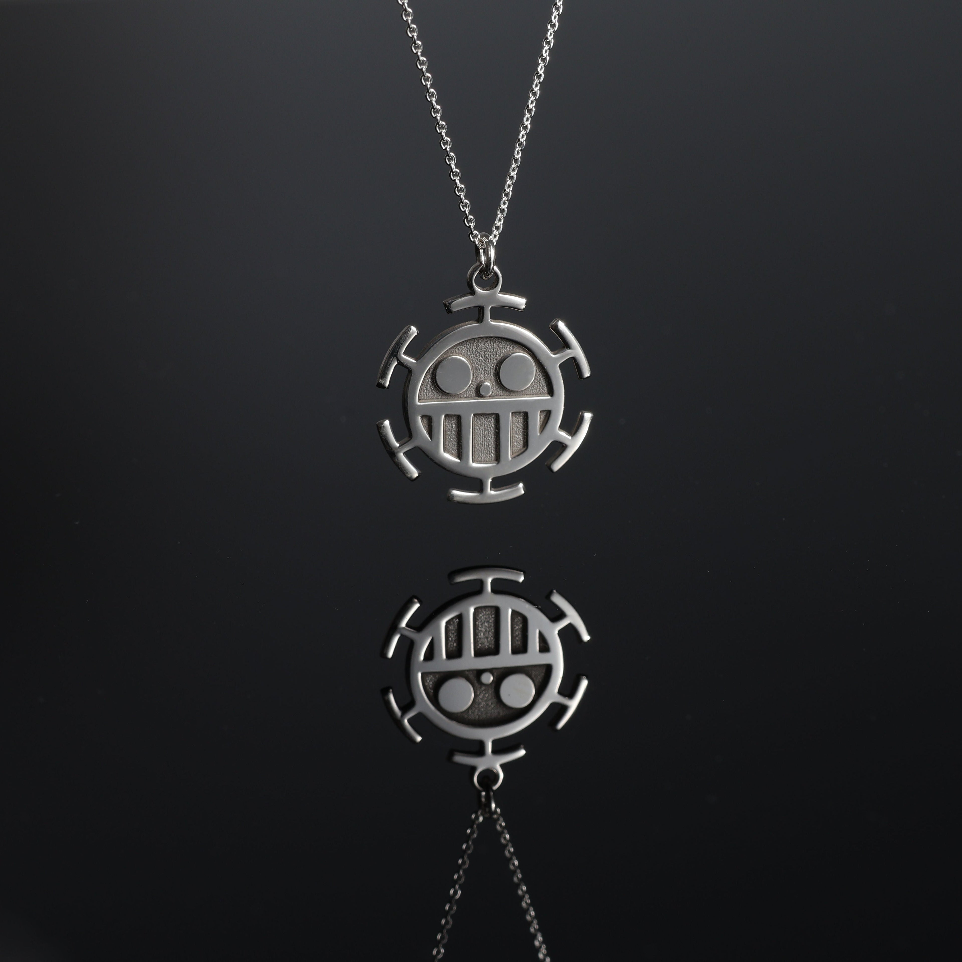 Detail and reflection of a sterling silver sea emblem necklace