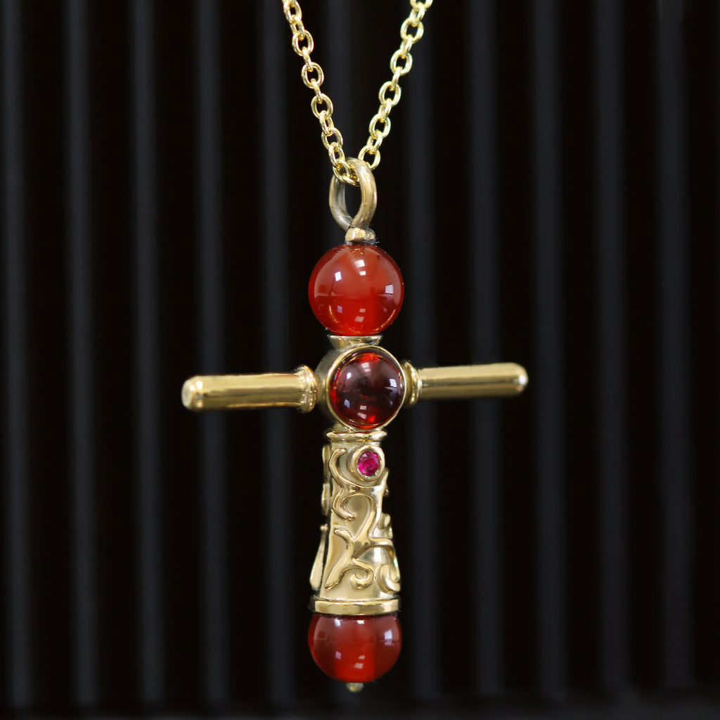 Second brave cross necklace detail with garnet cabochon and gold plated finish