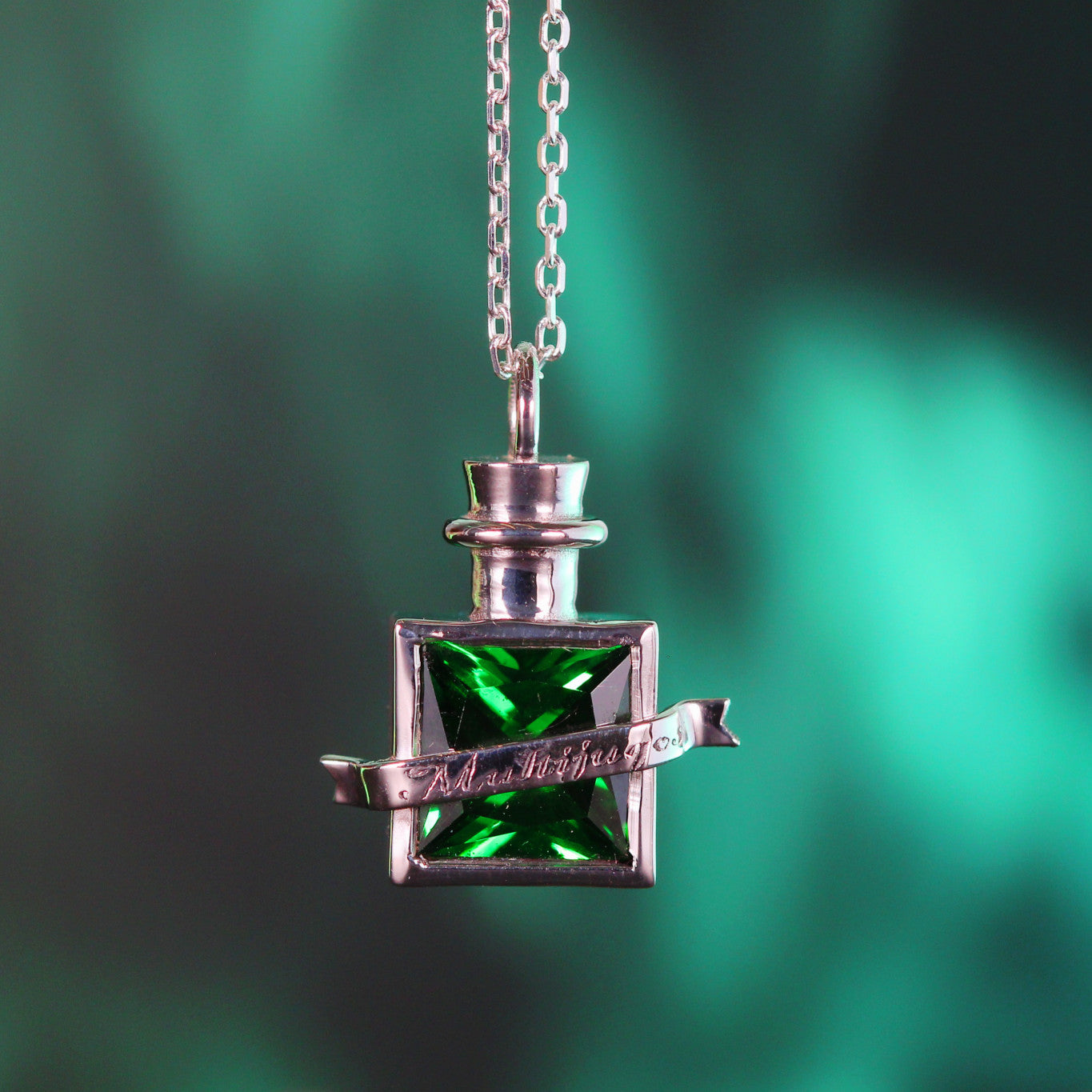 Close-up of transformation elixir pendant with green stone