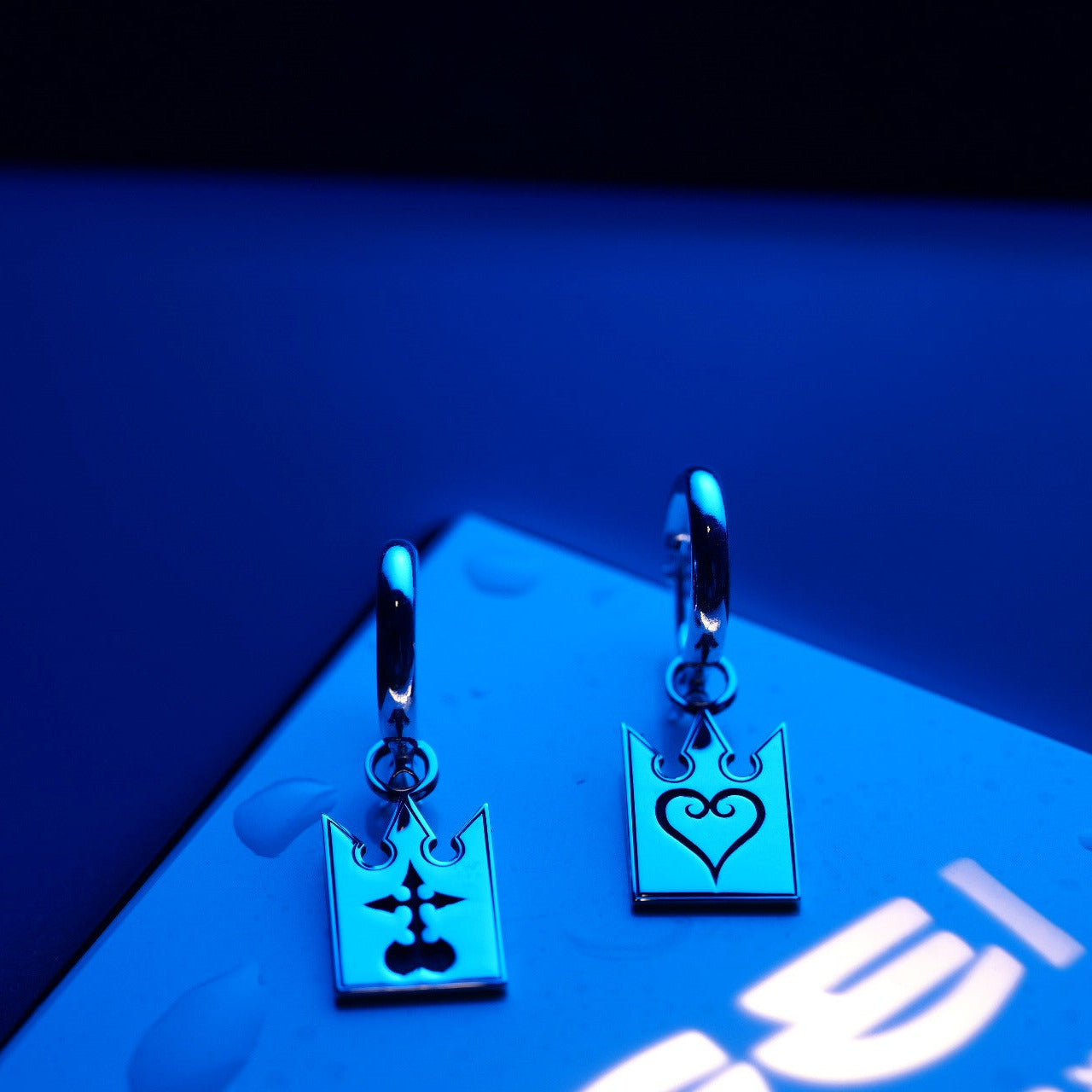 Unmei earrings worn, showing elegant card-shaped design with symbolic contrast