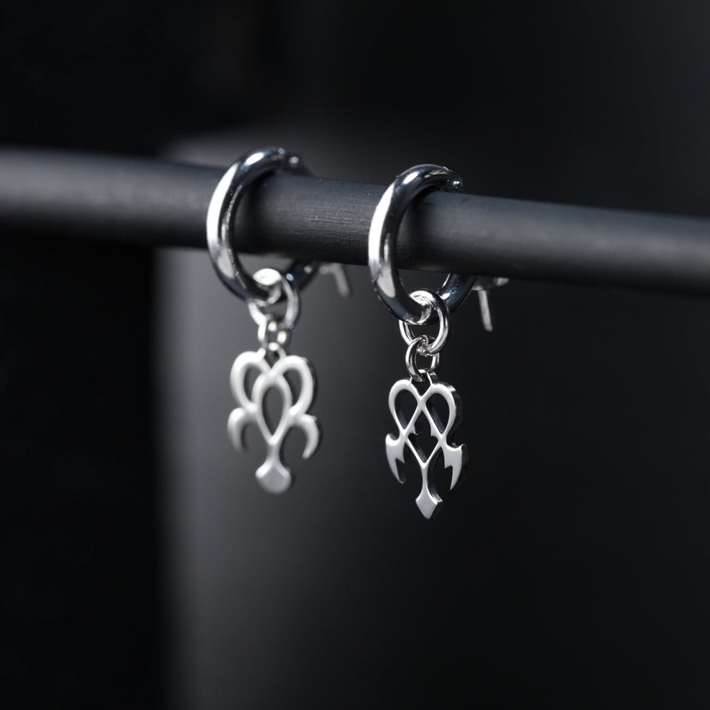 Detail of Yume hoop earrings showing contrast between rounded dream and sharp nightmare symbols