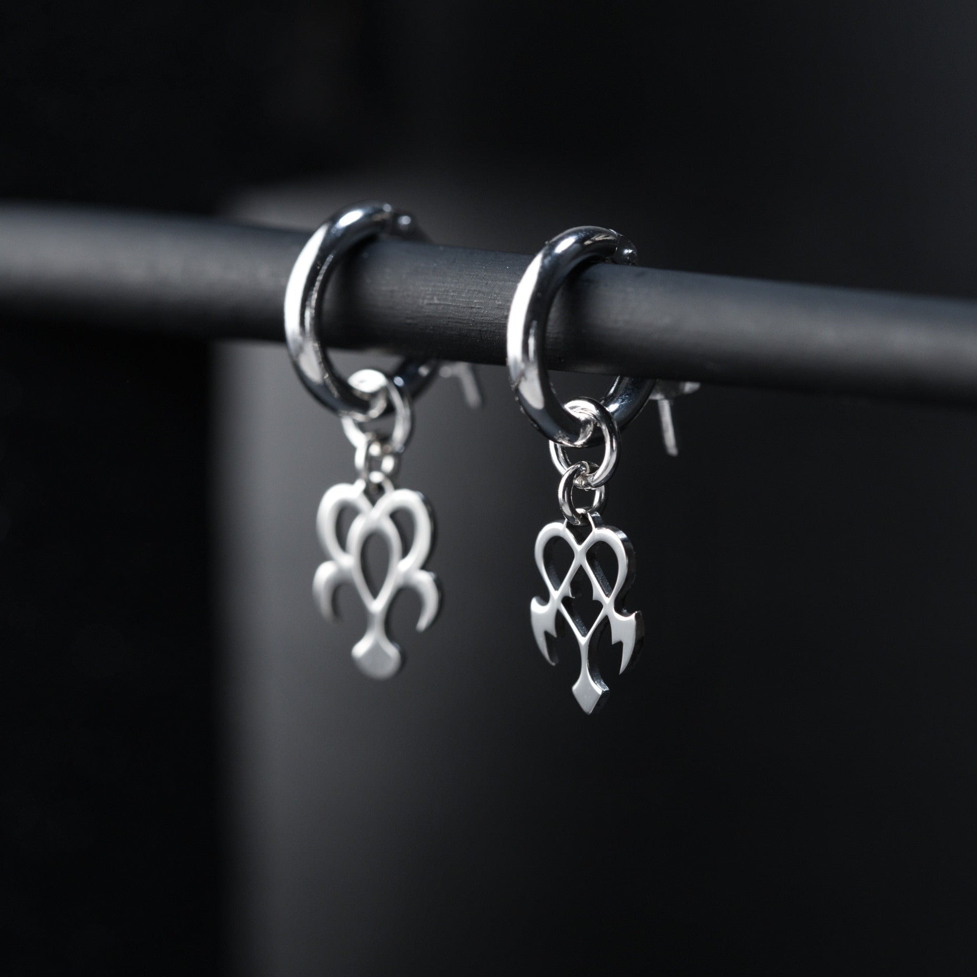 Detail of Yume hoop earrings showing contrast between rounded dream and sharp nightmare symbols